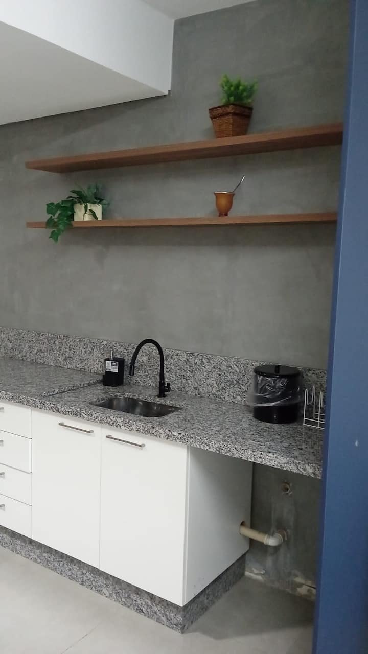 Pia da cozinha com bancada de granito e prateleiras