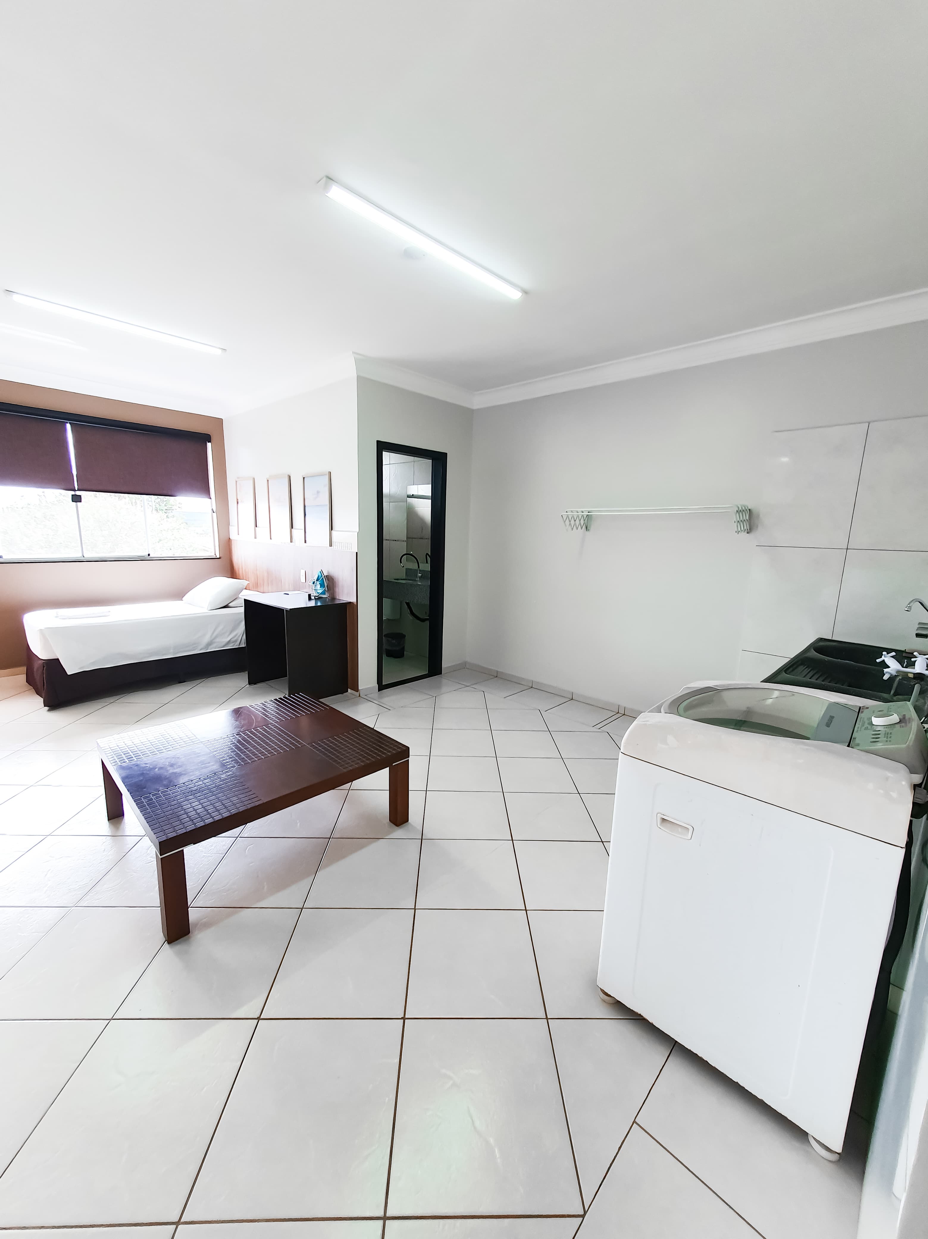 Área de serviço integrada ao quarto com máquina de lavar