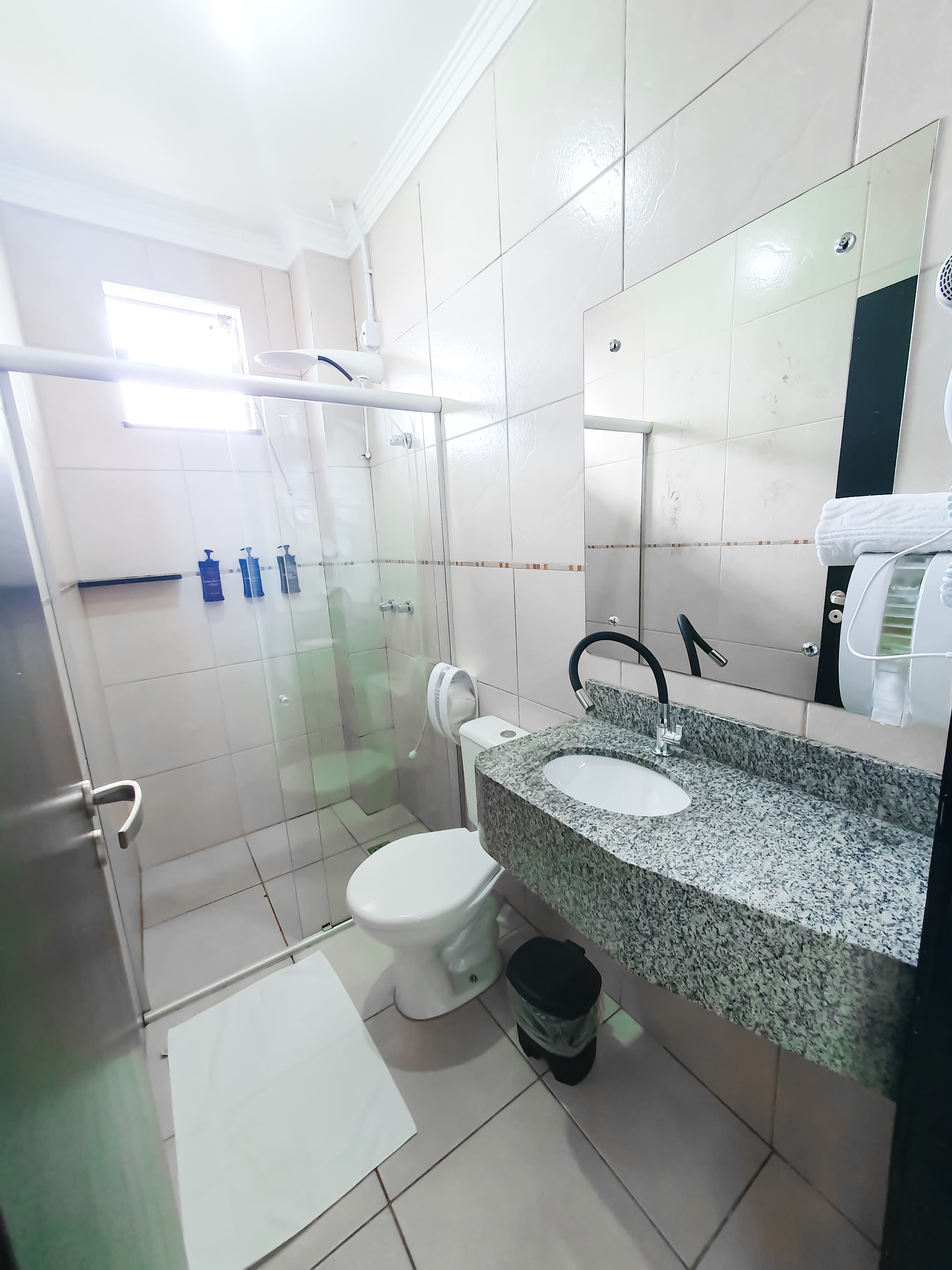 Banheiro completo do Loft 22 com pia, vaso e box de vidro