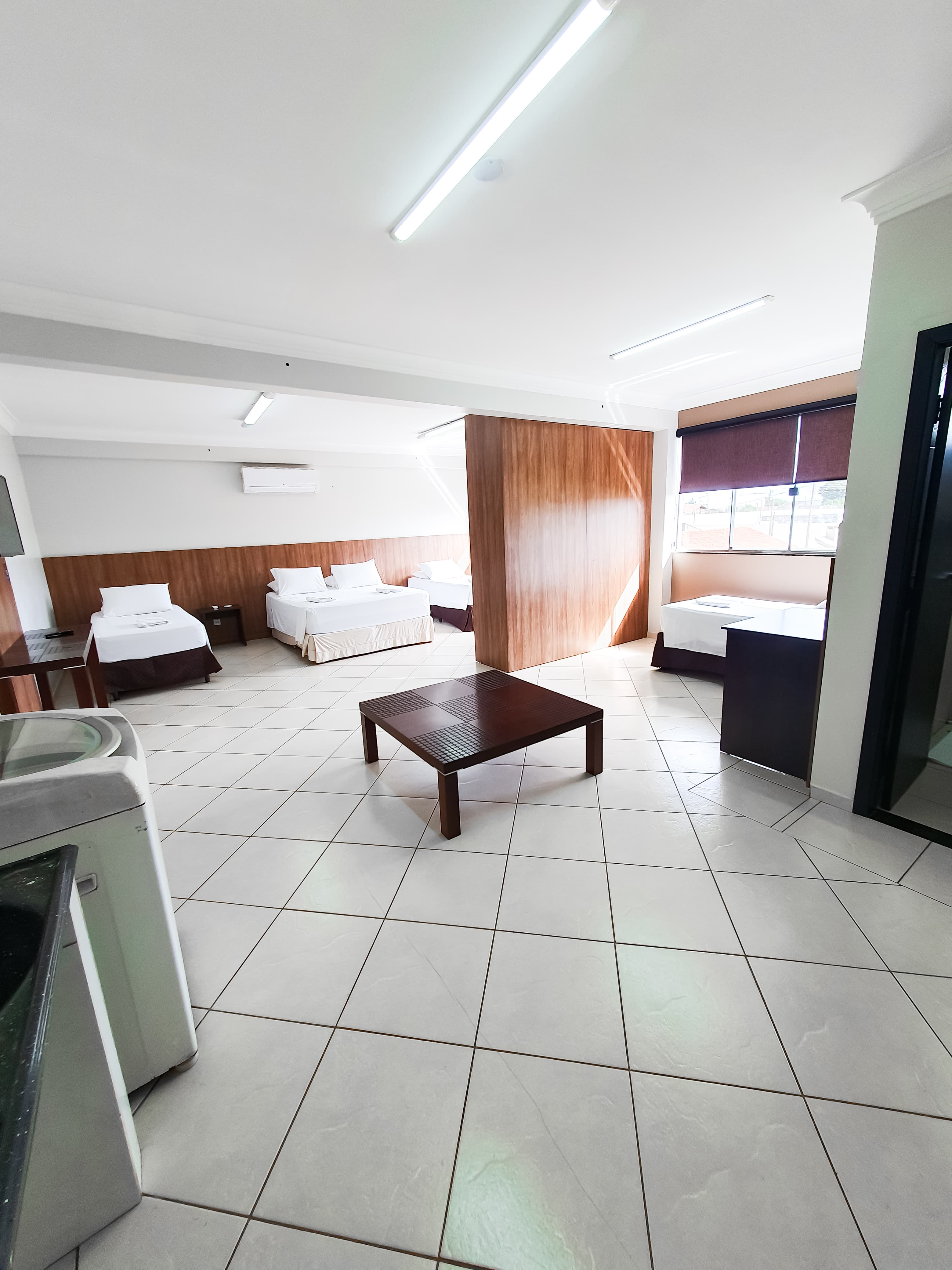Quarto do Loft 22 com múltiplas camas e divisória de madeira