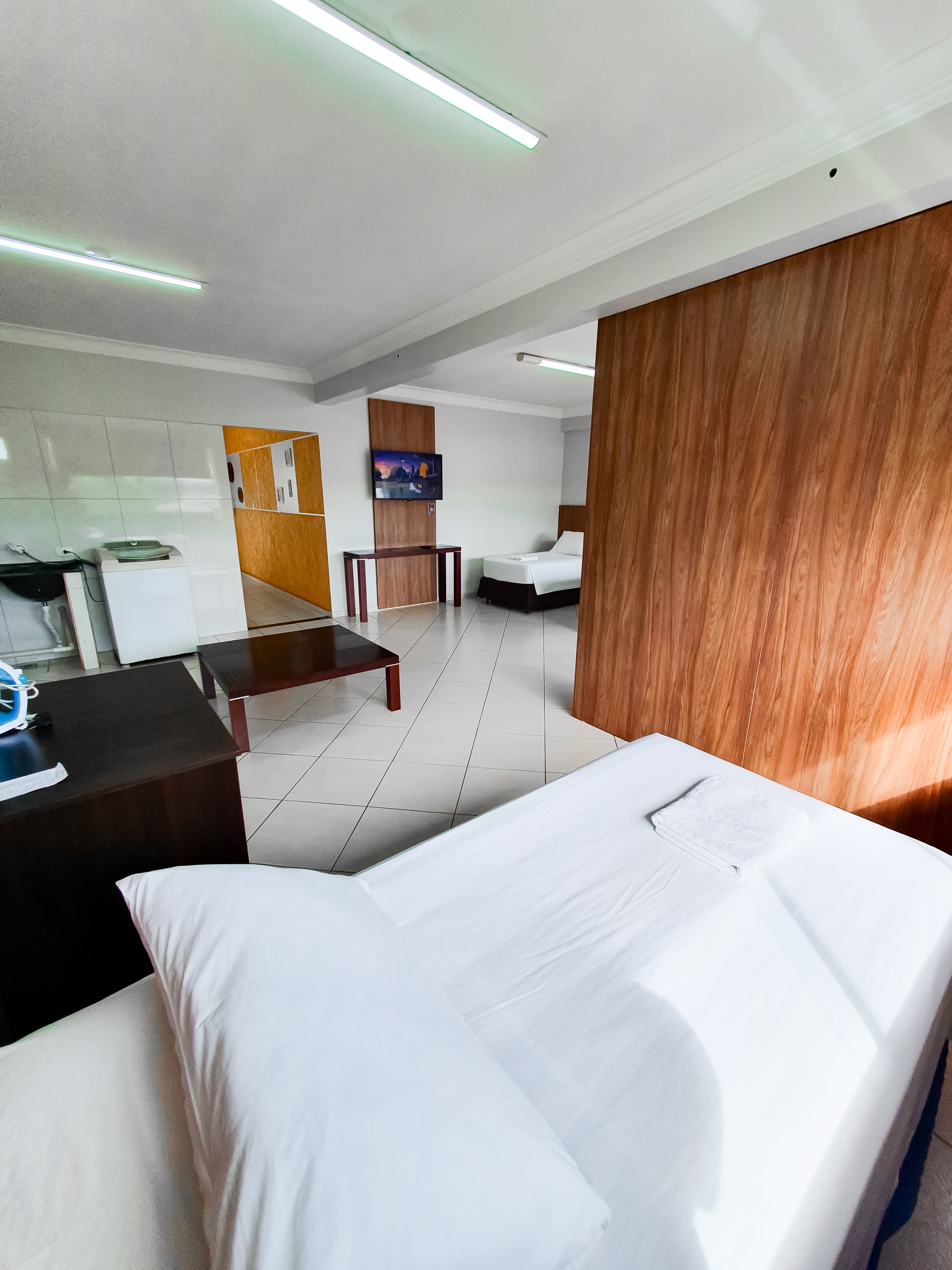 Vista geral do quarto do Loft 22 com camas e TV